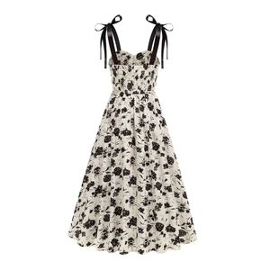 Détail d'une robe fleurie avec bretelles en satin nouées et dos élastiqué smocké