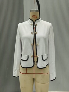 Dettaglio della trama in tweed bianco e bottoni dorati sulla giacca corta stile francese