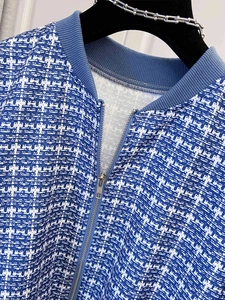 Close-up of blue and white tweed jacket with silver zipper and ribbed collar detail