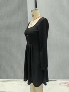 Detail of black ribbed knit dress with U-neck and three decorative front buttons
