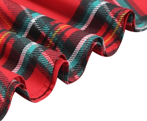 Detailed close-up of the red plaid skirt hem with elegant wavy pleats and fabric texture