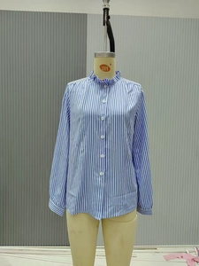 Detail of blue and white striped long sleeve shirt with ruffled collar and white buttons