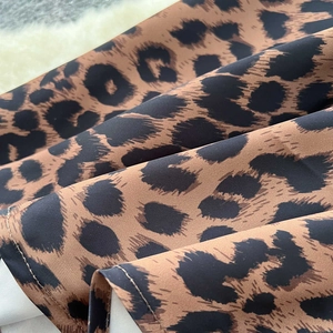 Macro del tessuto satinato leopardato con scritte FOG e dettagli di cucitura fini