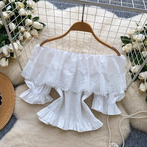 Dettaglio del top bianco con spalle scoperte in pizzo floreale e balze raffinate