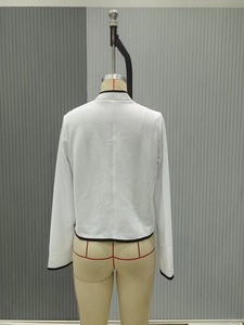 Dettaglio della giacca in tweed bianco stile francese con trama materica e bordo nero