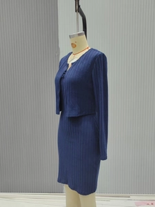 Detailed view of dark blue ribbed knit fabric on a slim-fit jacket and dress set