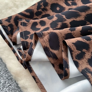 Dettaglio della gonna in raso leopardata con cuciture sull'orlo e trama del tessuto