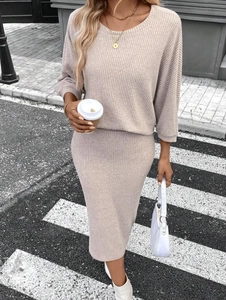 Détail d'un ensemble deux pièces en tricot beige à manches longues et jupe mi-longue
