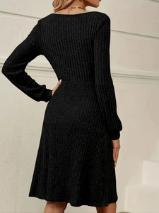 Detail of black ribbed knit dress showing long sleeves and slim fit texture