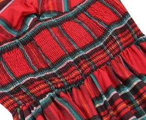 Detail of red tartan dress featuring elastic smocking and green plaid pattern accents