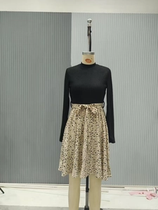Detail of the knit long sleeves and floral skirt with bow waist tie on the dress