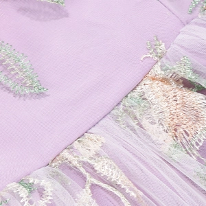 Detailed macro shot of lavender mesh fabric with intricate leaf floral embroidery