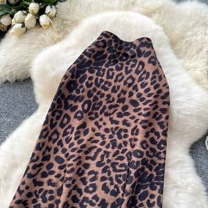 Dettaglio della texture della gonna in raso leopardato su sfondo di peluche bianco