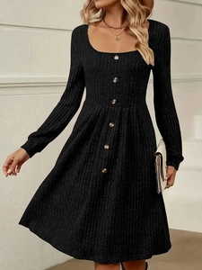 Detailed macro view of the ribbed knit fabric and decorative front buttons on black dress