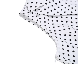 Détail d'une robe vintage à pois montrant le col à revers et le zip latéral invisible