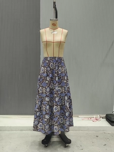 Dettaglio di una gonna lunga bohémien a fiori con vita alta e design a balze a strati