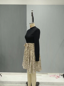 Detail view of long sleeve knit dress featuring floral print skirt and waist bow tie