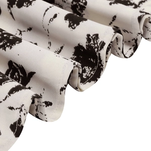 Vue macro d'un tissu imprimé floral blanc avec plis souples et coutures de précision
