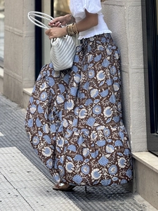 Dettaglio gonna lunga boho a vita alta con stampa a girasole e design a balze in contesto urban