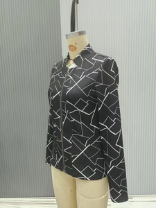 Detail shot of vintage style jacket featuring black fabric with white geometric line prints