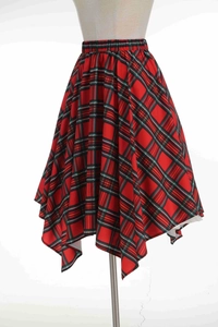 Détail de la jupe à carreaux rouge avec ourlet irrégulier et taille élastique