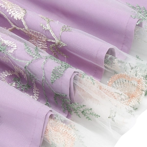Detail of purple embroidery on mesh fabric for a vintage style evening dress
