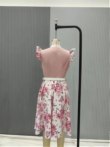 Rear view of vintage floral dress with pink bodice and ruffled cuffs on mannequin