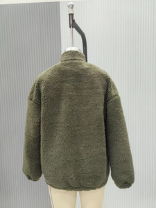 Back view of dark green faux shearling jacket showing textured fabric and elastic hem