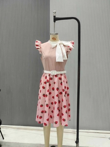 Detail of pink strawberry print dress with silk bow neckline and layered ruffle sleeves