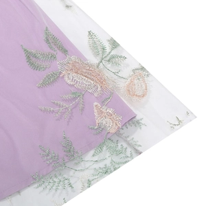 Detailed embroidery of pink flowers and green leaves on lavender mesh fabric