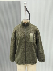 Detail of army green sherpa fleece jacket featuring a contrast chest zipper pocket