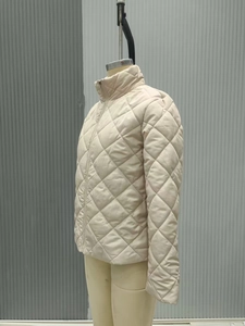 Detailed view of beige diamond quilted lightweight jacket with stand collar and zipper