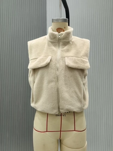 Detail view of beige fleece vest featuring stand-up collar and front flap pockets