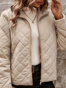 Detail of diamond quilted texture and zipper on women's elegant khaki warm winter jacket