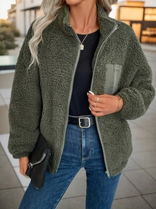 Close-up of dark green sherpa fleece jacket featuring a stand collar and nylon chest pocket
