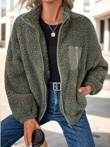 Detail of olive green faux shearling jacket featuring standing collar and nylon chest pocket
