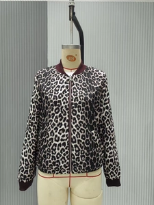Detail view of the zipper closure and burgundy ribbed cuffs on leopard print bomber jacket