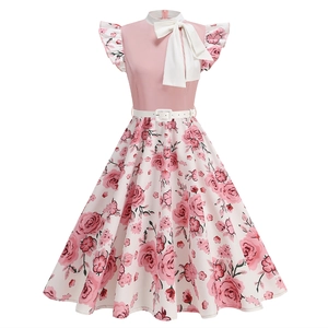 Detail view of pink sleeveless dress with white collar, large bow, and rose floral pattern