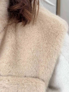 Close-up of thick beige faux fur vest showing dense texture and soft winter material