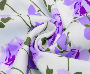 Makroaufnahme von lila Blumenstoff mit Textur und elegantem Spiraldrapierung