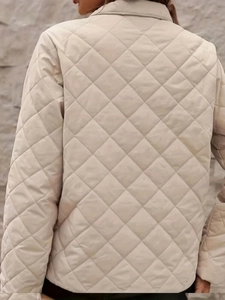 Detail view of the beige diamond-quilted jacket back and collar for autumn and winter