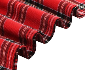 Vue détaillée du tissu plissé de la jupe à carreaux rouge et noir au motif écossais