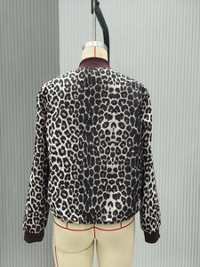 Back view of a leopard print reversible jacket featuring burgundy ribbed cuffs and hem