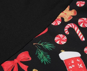 Close-up of festive Christmas print featuring gingerbread men and candy canes on black fabric