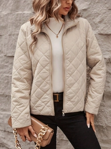 Detail of elegant beige diamond-quilted jacket featuring lapel collar and zip closure