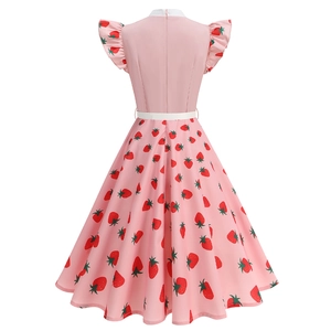 Detail view of the pink retro strawberry print dress with a white waist belt and ruffles