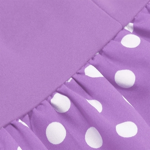 Detailed close-up of purple fabric with white polka dots and delicate pleated stitching