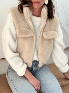 Detail of soft beige faux fur vest showing high collar and front metal zipper design