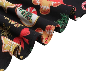 Detailed view of Christmas gingerbread man and tree prints on black vintage swing dress fabric