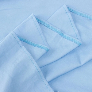 Macro view of light blue fabric showing professional overlock stitching and fine texture